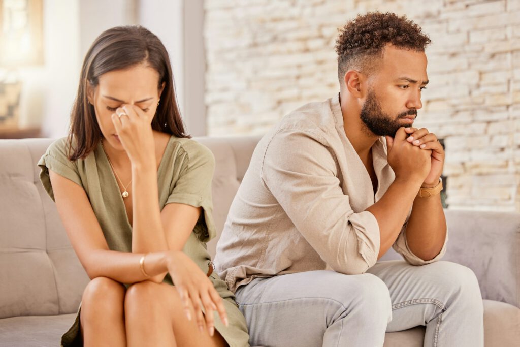 Couple, divorce or stress on living room sofa in house, home or marriage counseling after fight, ar